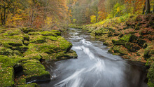 Fast Flowing River Surrounded By By Autumn Colors