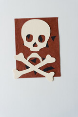 Wall Mural - paper skull and crossbones isolated on paper with black shapes