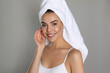 © New Africa - Beautiful young woman with towel on head against grey background