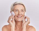 Fototapeta Panele - Grooming, skincare and hygiene by a mature woman apply cleanser or toner to her face with cotton pads. Senior female remove makeup and enjoying a routine pamper facial treatment against copy space