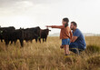 © Nina Lawrenson/peopleimages.com - Family, dairy farming and farmer with child, daughter and girl pointing, showing and watching cows or cattle. Father and curious kid bonding on farm estate with meat, beef and food industry livestock