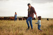 © Nina Lawrenson/peopleimages.com - Sustainable farming family, cows on agriculture farm with rustic, countryside or nature grass background. Farmer mother, dad and kids with cattle or livestock animals for dairy, beef or meat industry