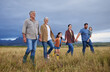 © Nina L/peopleimages.com - Big happy family walking on field, meadow and countryside in nature to relax, bond and holding hands in love, trust and support. Generation of grandparents, parents and kids having fun outside