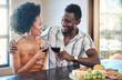 © Kirsten Davis/peopleimages.com - Young couple celebrating with wine and cheers at resort, laugh and bonding on romantic date. Carefree, in love black girlfriend and boyfriend toasting, enjoying relationship, alcohol and conversation