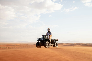 female traveler riding quad bike through desert of namibia