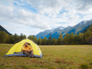 Wall Mural - trip to Caucasus mountains, Arkhyz, Teberdinsky reserve. Man traveler relaxing in mountains in tent camping outdoor Travel adventure lifestyle concept hiking active vacations.