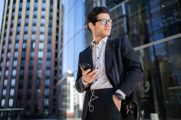 Wall Mural - A man holding a phone is a manager, an employee in a financial company, goes to the office in a business suit, builds a career