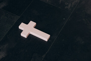 Wall Mural - Christian cross on a textured black background. Religion concept. Pink cross