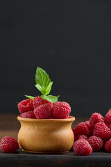 Wall Mural - Ripe red raspberries on a brown wooden board