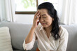 © Charlie's - Middle age Asian woman touching forehead having headache suffering from. migraine feeling sick or depression
