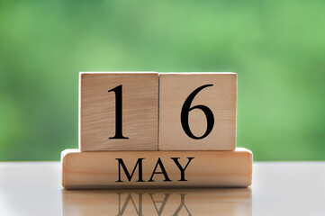 May 16 calendar date text on wooden blocks with blurred nature background. Copy space and calendar concept