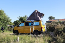 A New Yellow Camper Van With A Roof Tent