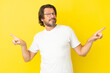 © luismolinero - Senior dutch man isolated on yellow background pointing finger to the laterals and happy