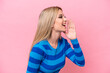 © luismolinero - Pretty blonde woman isolated on pink background shouting with mouth wide open to the side