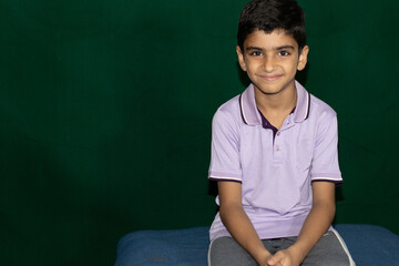 Wall Mural - portrait of a smiling boy with green background