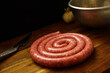© Luca - rolled sausage Luganega on wooden cutting board. pork, typical Italian sausage
