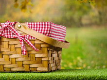 Close-up. Picnic Basket On The Background Of Beautiful Autumn Nature, Golden Fallen Leaves. Thanksgiving Celebration, Outdoor Recreation, Delicious Healthy Food. Banner, Invitation.