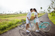 romantic young couple put their head together while riding bicycle outdoor