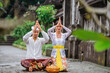 © Odua Images - balinese couple do the prayer to god in the morning. hindu people make an offering to their god using canang