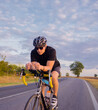 © Solid photos - Young sports man cycling with bicycle on the road in summer