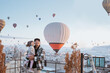 © Odua Images - happy family looking at hot air balloon flying around them when visiting cappadocia turkey in winter