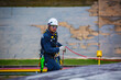 © chitsanupong - Male worker inspection wearing safety first harness rope safety line working at a high place on tank roof spherical gas  blue sky