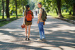 portrait of students in a city park, teenage schoolchildren a boy and a girl walking along a path, rear view