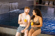 Young couple enjoying in indoor swimming pool on vacation