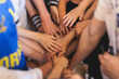 © tsuguliev - Team of kids children basketball players stacking hands in the court, sports team together holding hands getting ready for the game, playing indoor basketball, team talk with coach, close up of hands