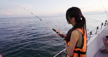 Woman Go Fishing On The Boat At Sunset Time