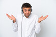 © luismolinero - Telemarketer Brazilian man working with a headset isolated on white background having doubts while raising hands