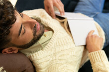 Young Ethnic Man Sleeping On Couch With Opened Book