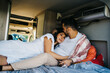 © ADDICTIVE STOCK - Loving ethnic couple of travelers lying in van