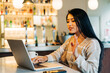© ADDICTIVE STOCK - Asian woman having video chat on laptop in cafe