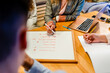 © ADDICTIVE STOCK - Business trainer showing whiteboard with words to unrecognizable employees indoors