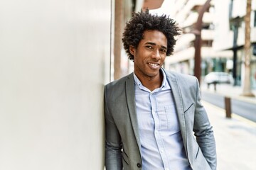 Wall Mural - Young african american businessman smiling happy standing at the city.