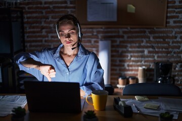 Sticker - Beautiful brunette woman working at the office at night looking unhappy and angry showing rejection and negative with thumbs down gesture. bad expression.