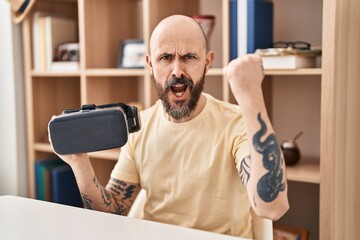 Canvas Print - Young hispanic man wearing virtual reality glasses annoyed and frustrated shouting with anger, yelling crazy with anger and hand raised