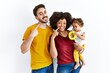 © Krakenimages.com - Interracial young family of black mother and hispanic father with daughter smiling cheerful showing and pointing with fingers teeth and mouth. dental health concept.