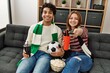 © Krakenimages.com - Young hooligan couple smiling happy supporting soccer team sitting on the sofa at home.