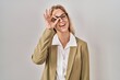 © Krakenimages.com - Young caucasian woman wearing glasses smiling happy doing ok sign with hand on eye looking through fingers