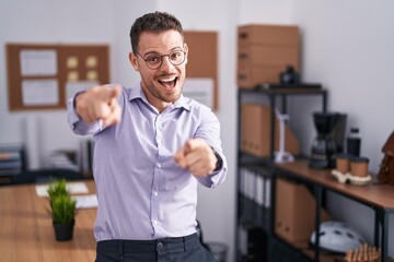 Poster - Young hispanic man at the office pointing to you and the camera with fingers, smiling positive and cheerful