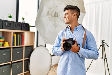 Sticker - Young hispanic man photographer using professional camera at photography studio