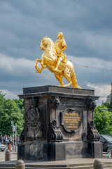 Wall Mural - Golden statue of King August II, golden rider, dressed as a Roman Caesar riding a horse over historical and touristic center in Dresden downtown, Dresden, Germany, at summer sunny day and dramatic sky