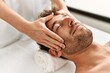 © Krakenimages.com - Young hispanic man having facial massage at beauty center