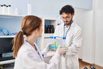 Sticker - Man and woman scientist partners holding test tubes at laboratory