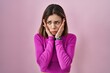Hispanic woman standing over pink background tired hands covering face, depression and sadness, upset and irritated for problem