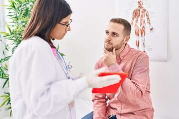 Wall Mural - Man and woman doctor and patient using touchpad at clinic