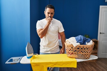 Sticker - Young hispanic man with beard ironing clothes at home feeling unwell and coughing as symptom for cold or bronchitis. health care concept.