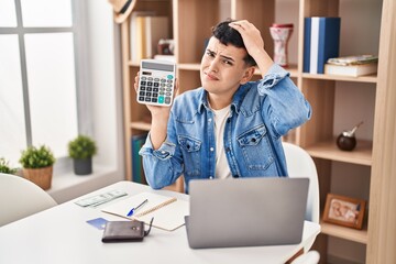 Wall Mural - Non binary person calculating money savings stressed and frustrated with hand on head, surprised and angry face